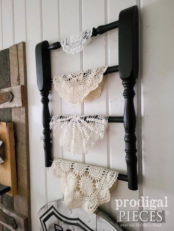 Cream doilies draped over a black wooden wall rack