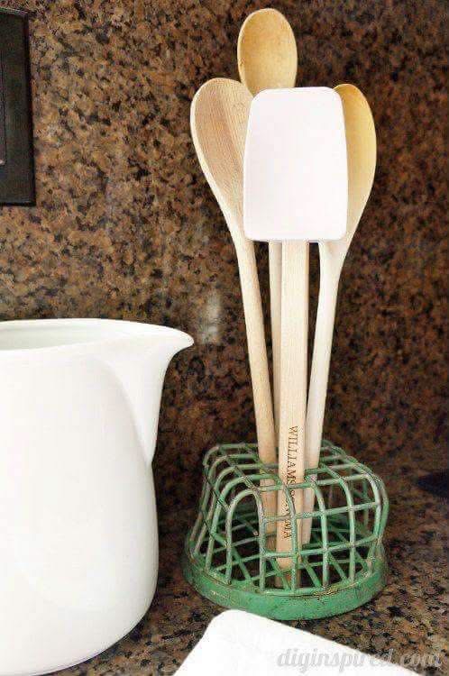 Wooden kitchen utensils held in a green cage flower frog
