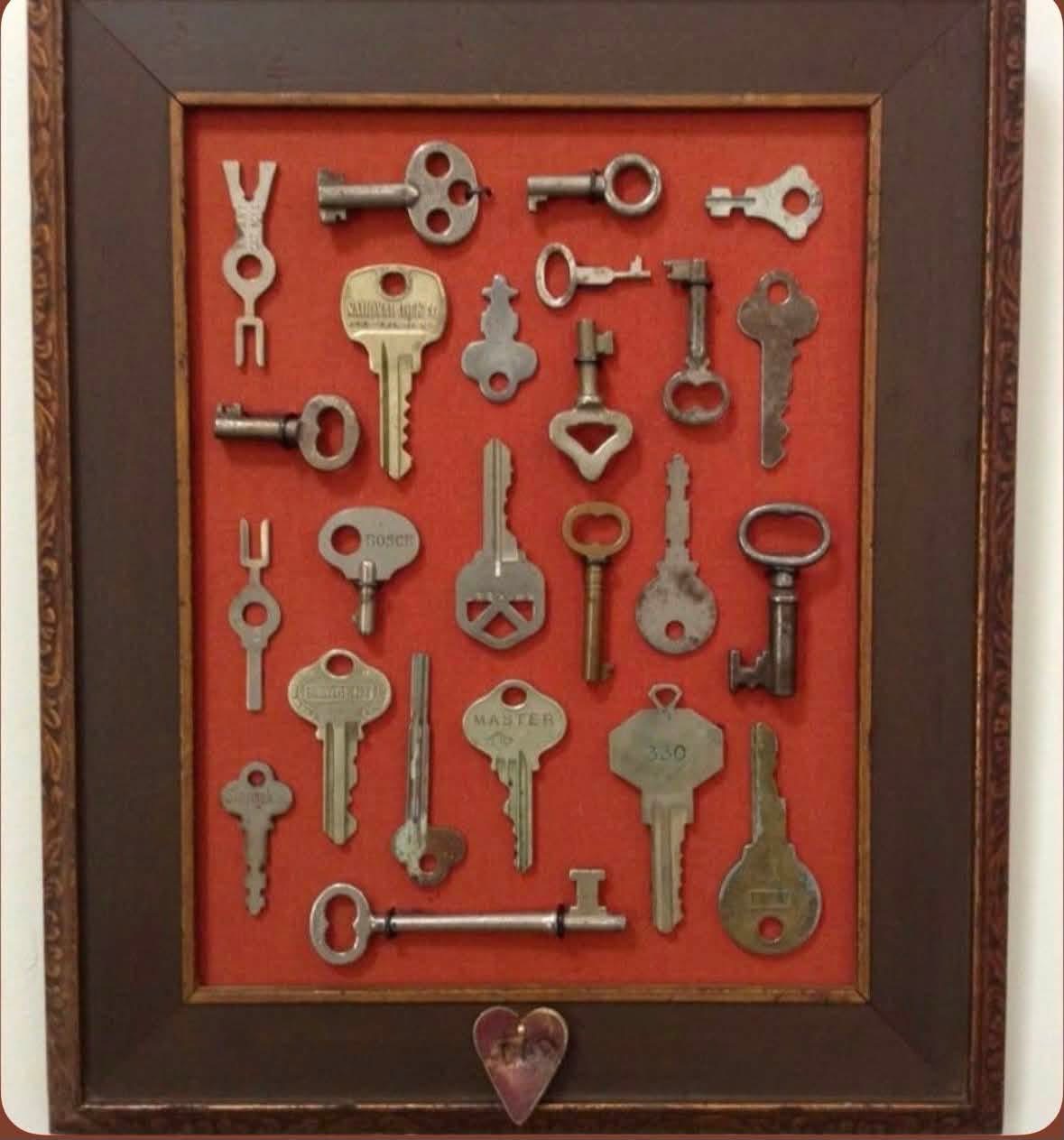 Collection of old keys mounted against a red background