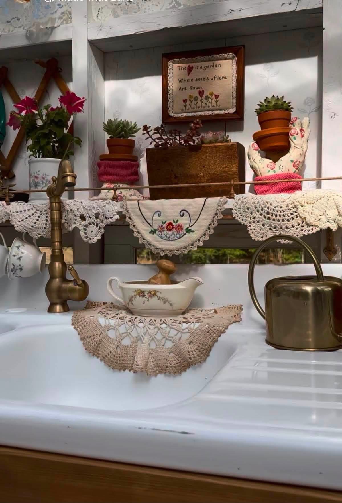 Doilies and embroidered linens decorating a kitchen sink and window