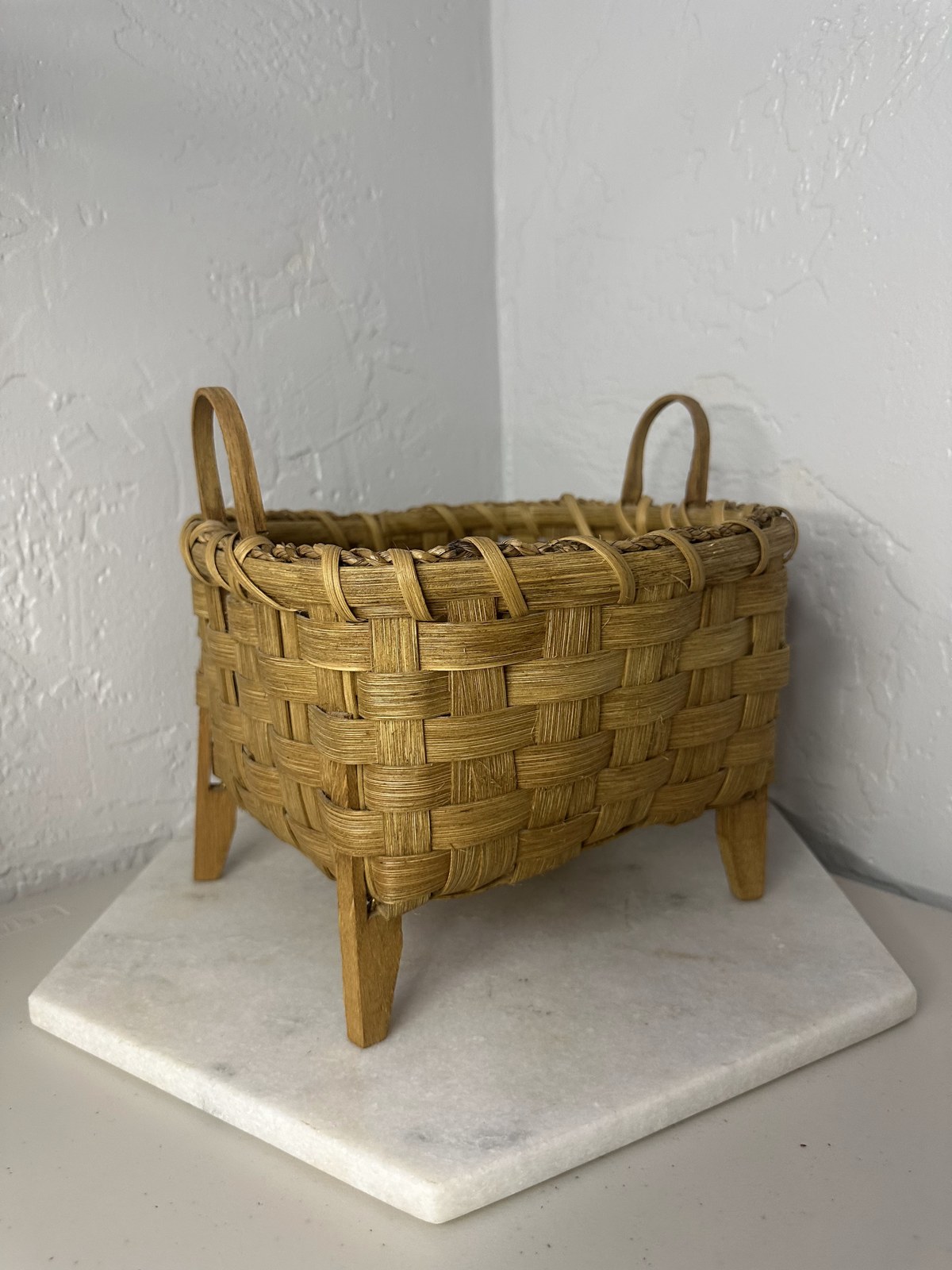 Woven basket on wooden legs