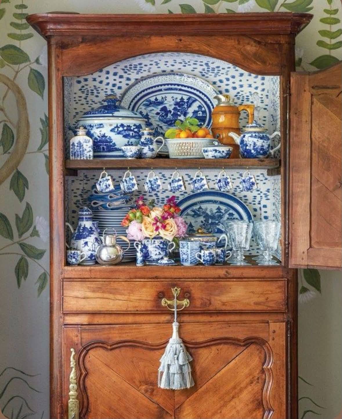 Blue and white dishes arranged in a wooden cupboard