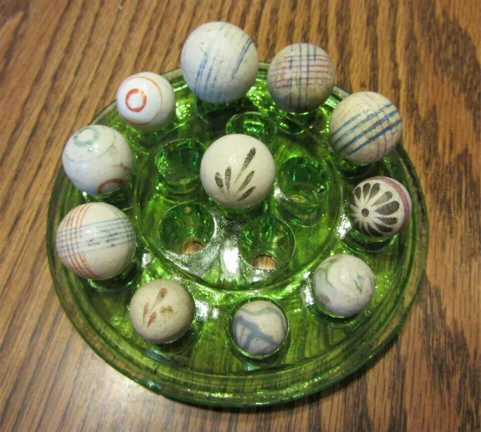 Patterned marbles displayed in a green glass flower frog