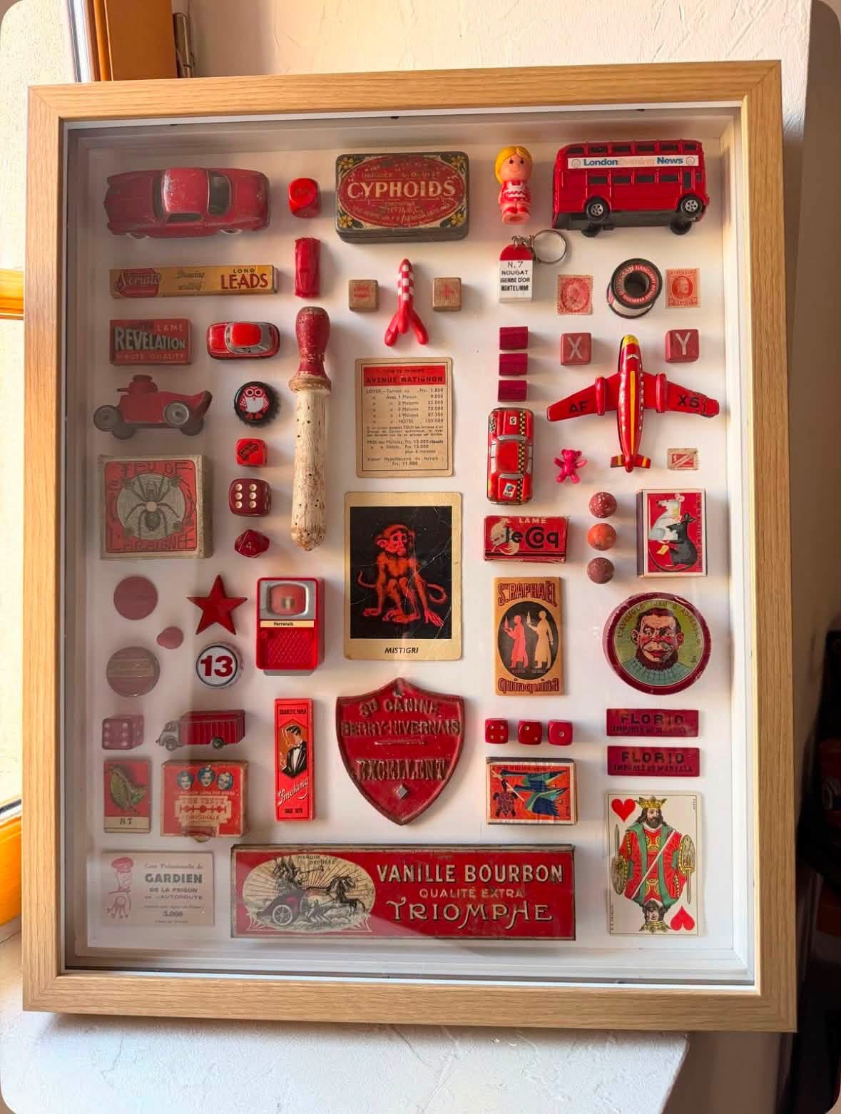 Red vintage objects arranged in a framed shadowbox