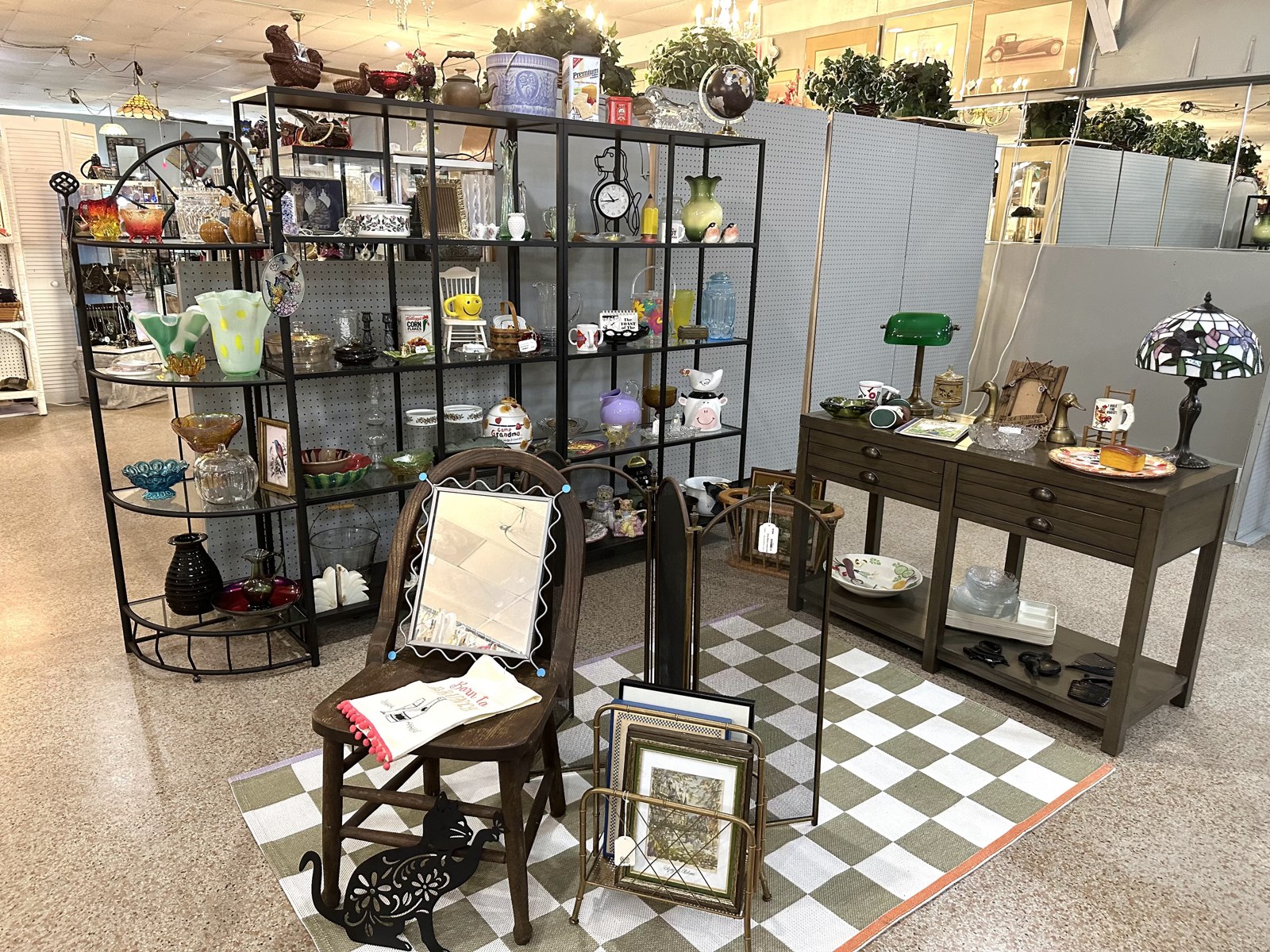 House of Coop vintage booth in Bradenton, with glassware, furniture, lamps and framed art