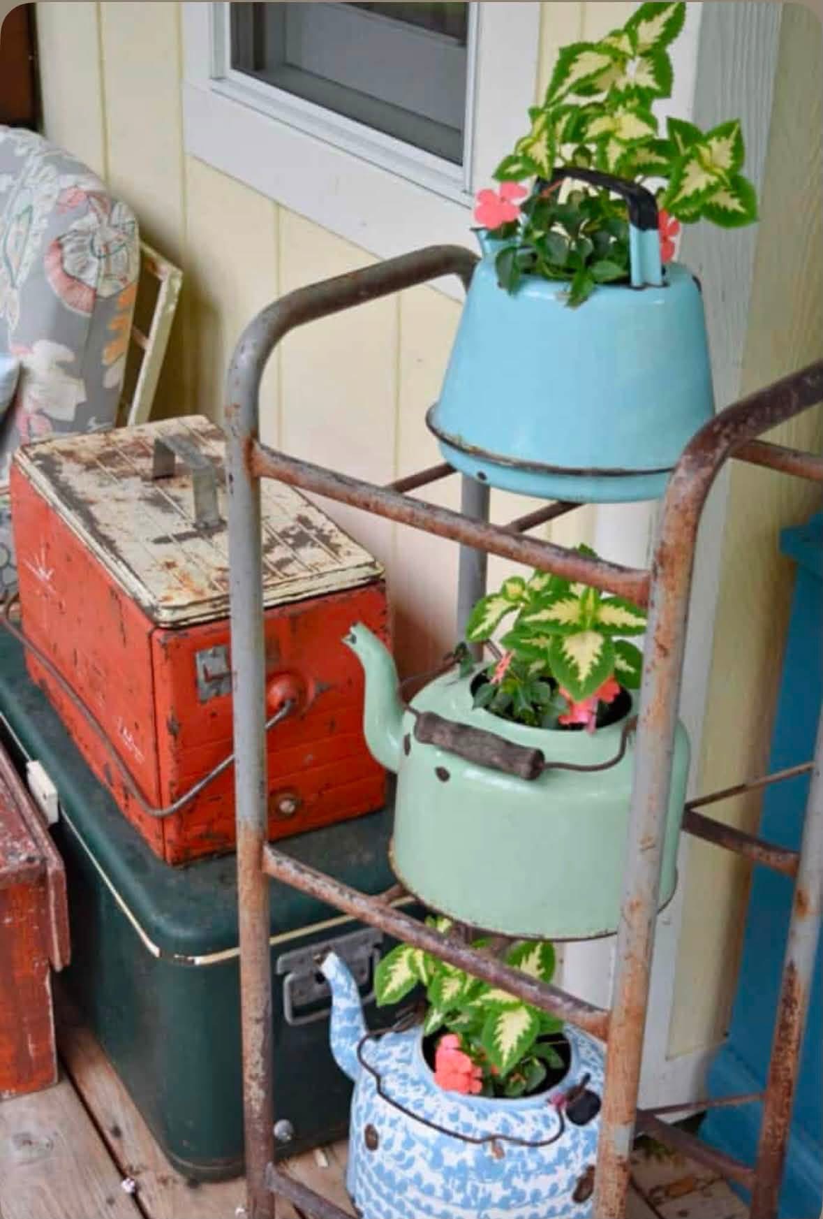Colorful kettle planters hanging from a metal rack