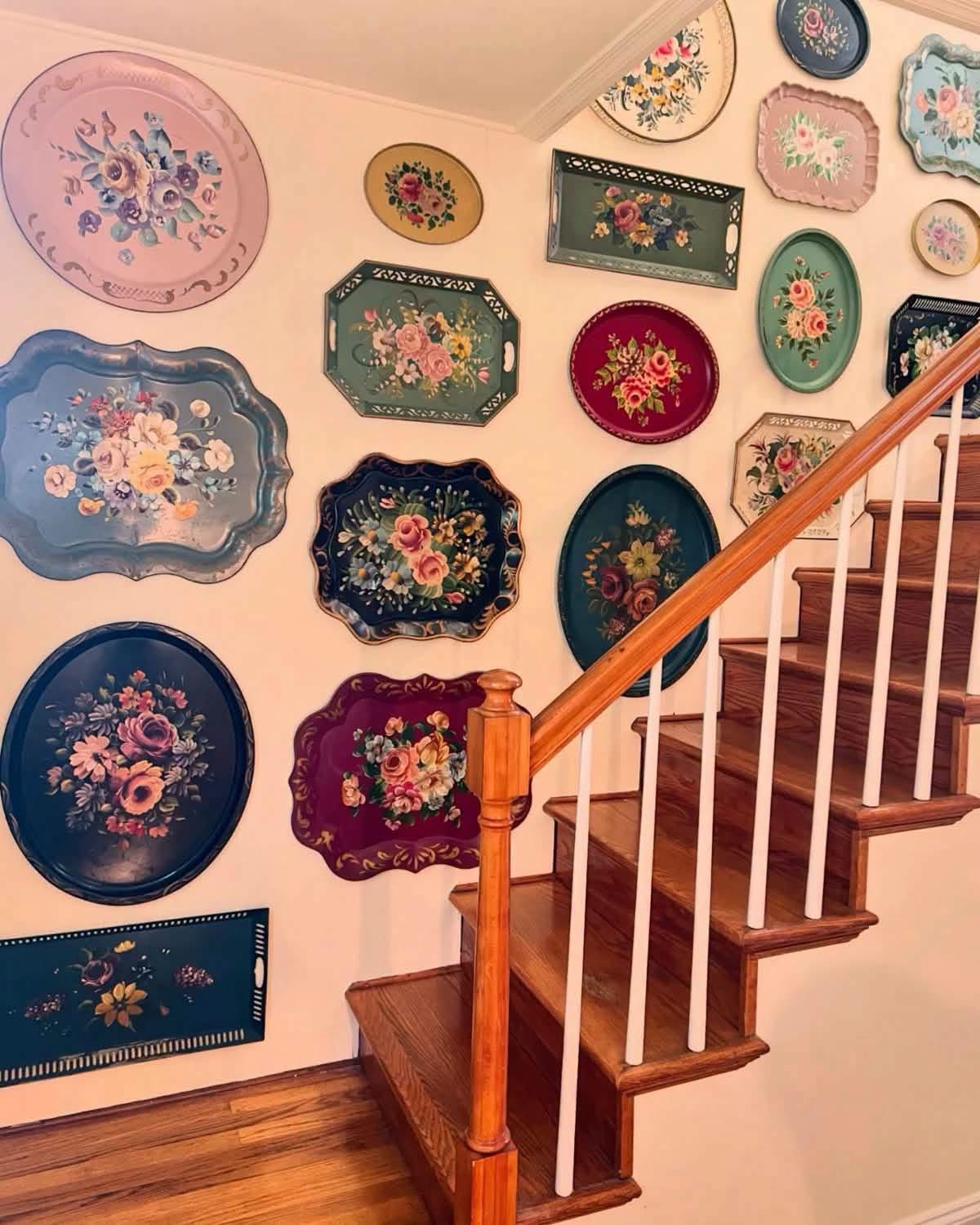 Painted floral trays displayed along a staircase