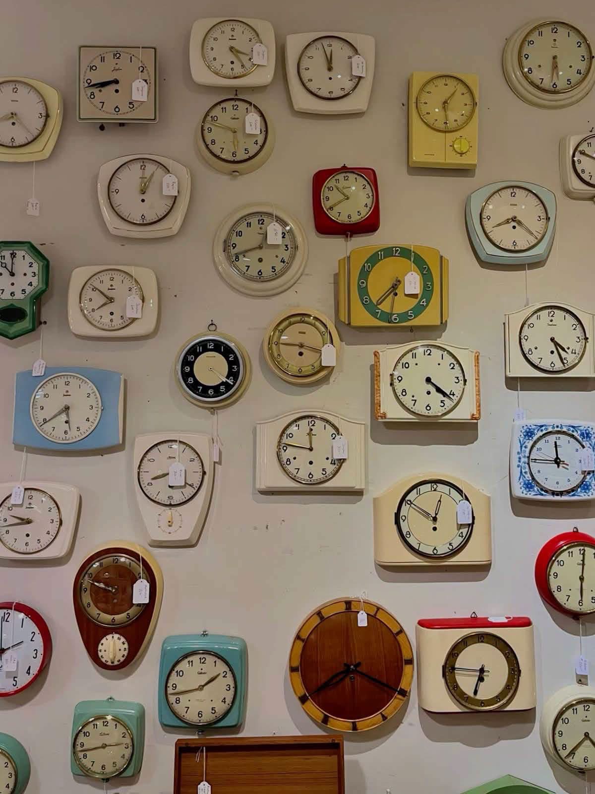 Colorful vintage kitchen clocks arranged on a wall