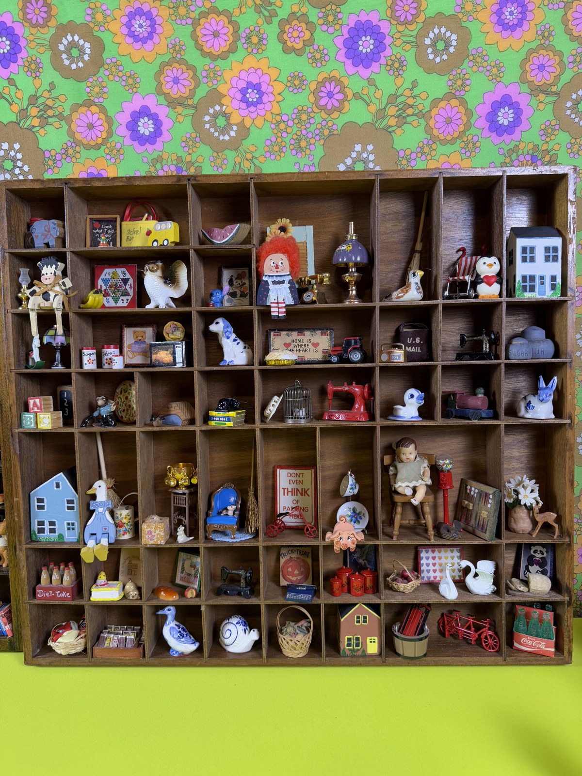 A wooden display filled with miniature vintage finds for the mini show