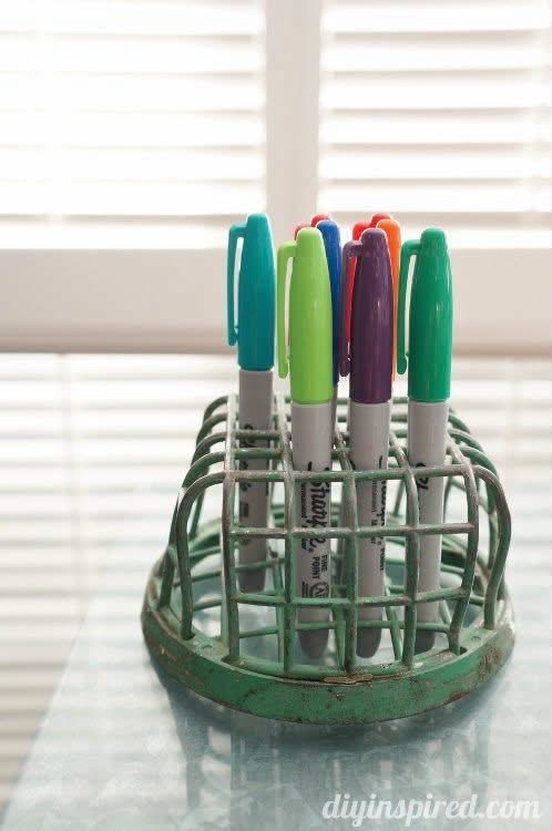 Colored markers organized in a green cage flower frog