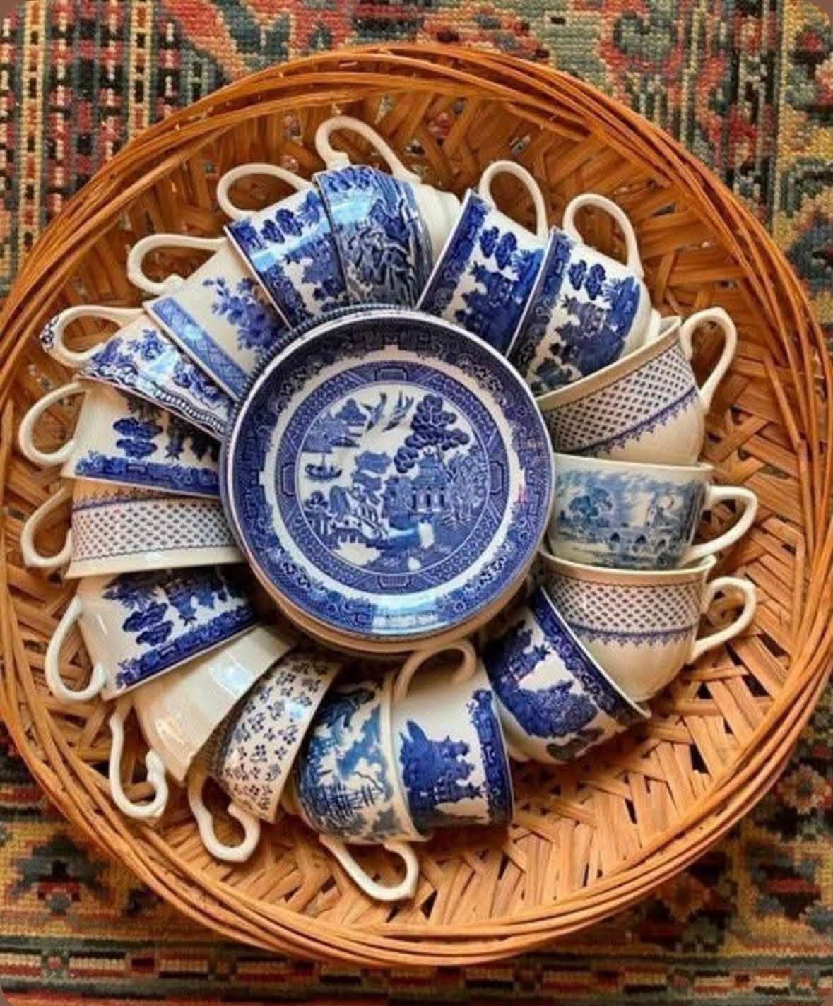 Blue and white teacups and saucers gathered in a wicker basket