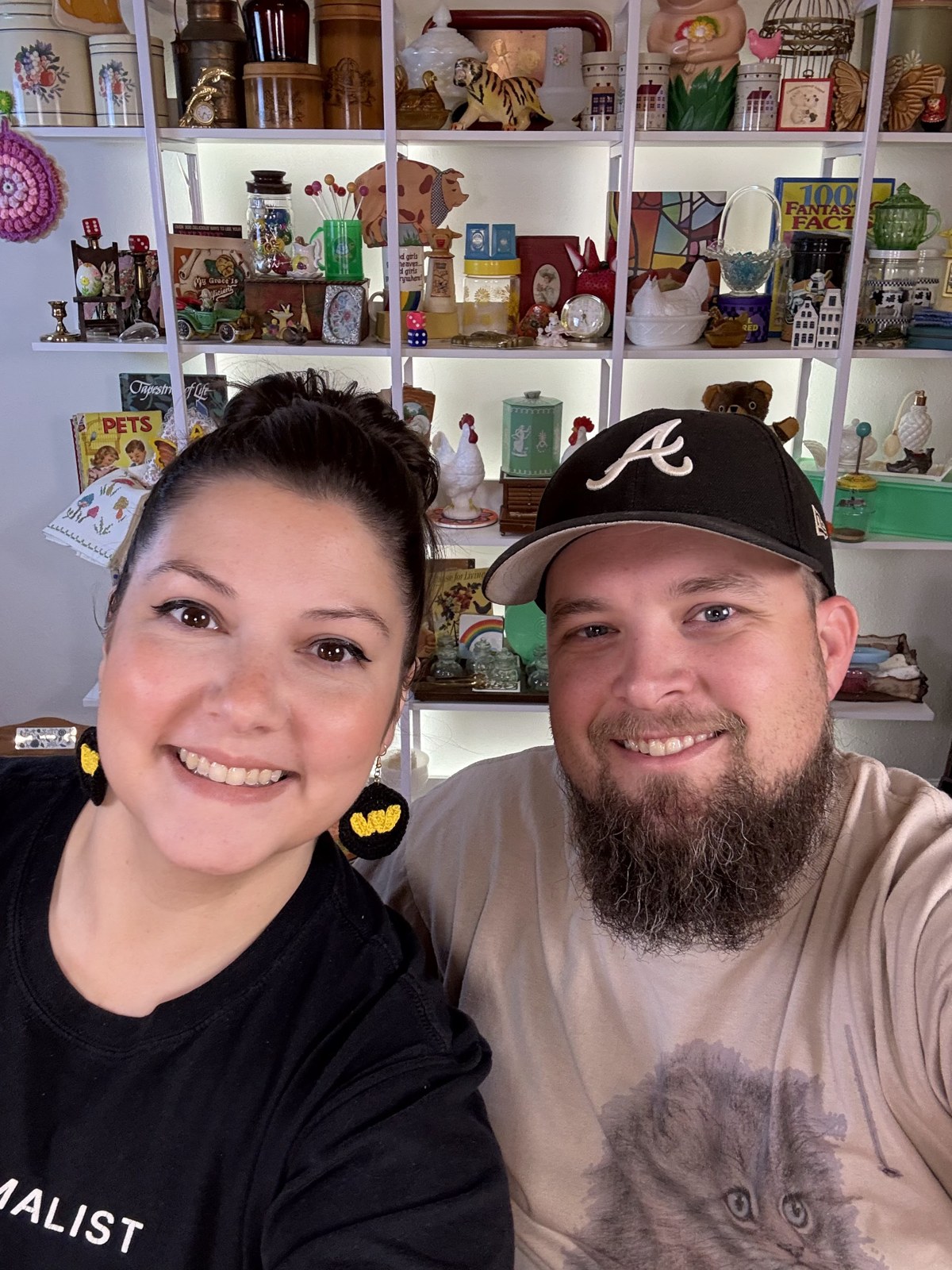 A couple together in front of the studio shelves