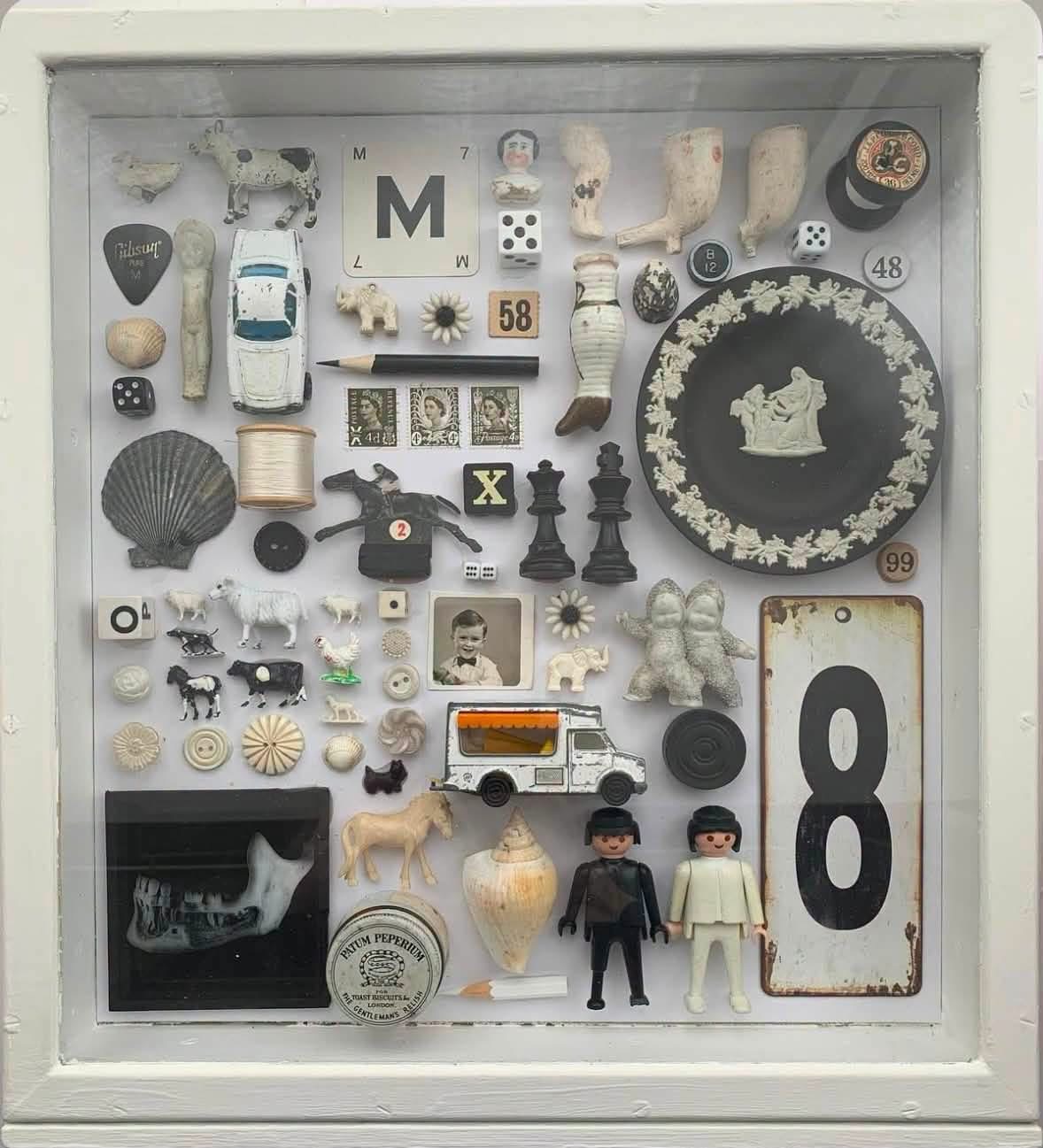 Black and white vintage objects in a white shadowbox