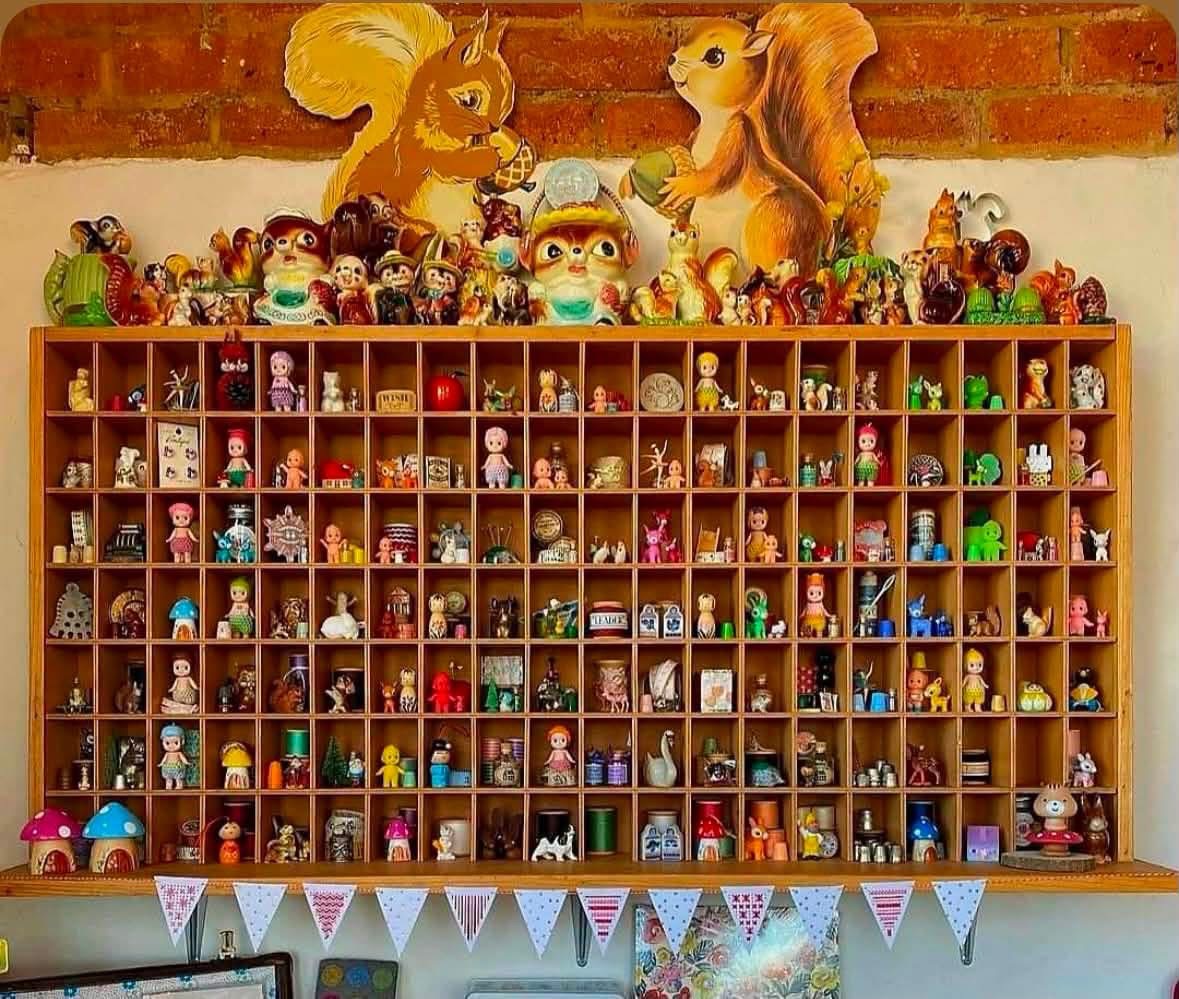 Wide compartment shelf filled with miniature figures and keepsakes