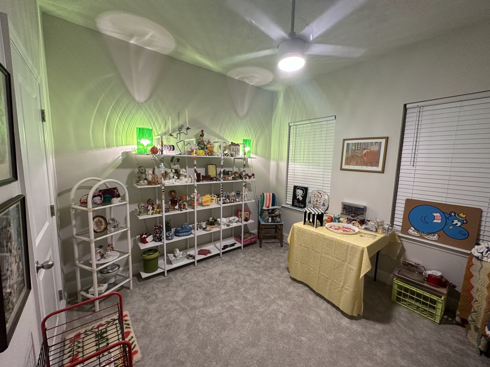 Whatnot selling space set up in the guest room with vintage displays and green lamps
