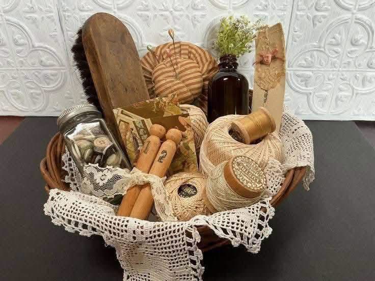 A doily lined basket holding thread and vintage sewing supplies