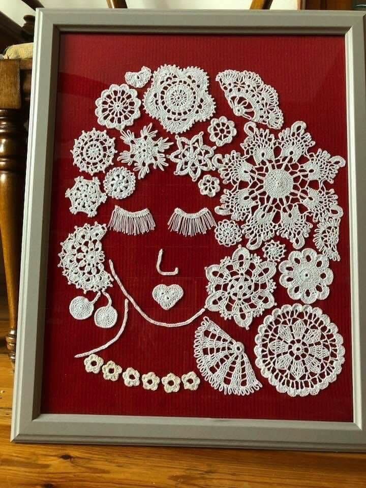 A face and flowing hair created from white lace on a red background