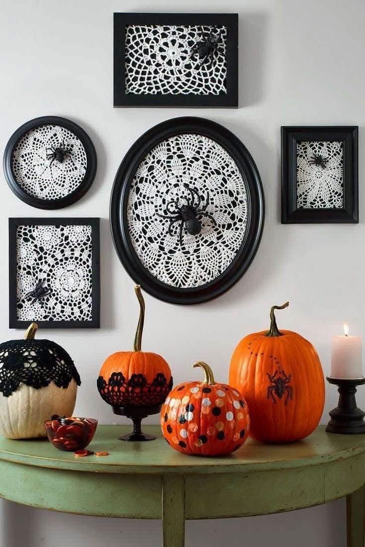 Black framed doilies with decorative spiders above Halloween pumpkins