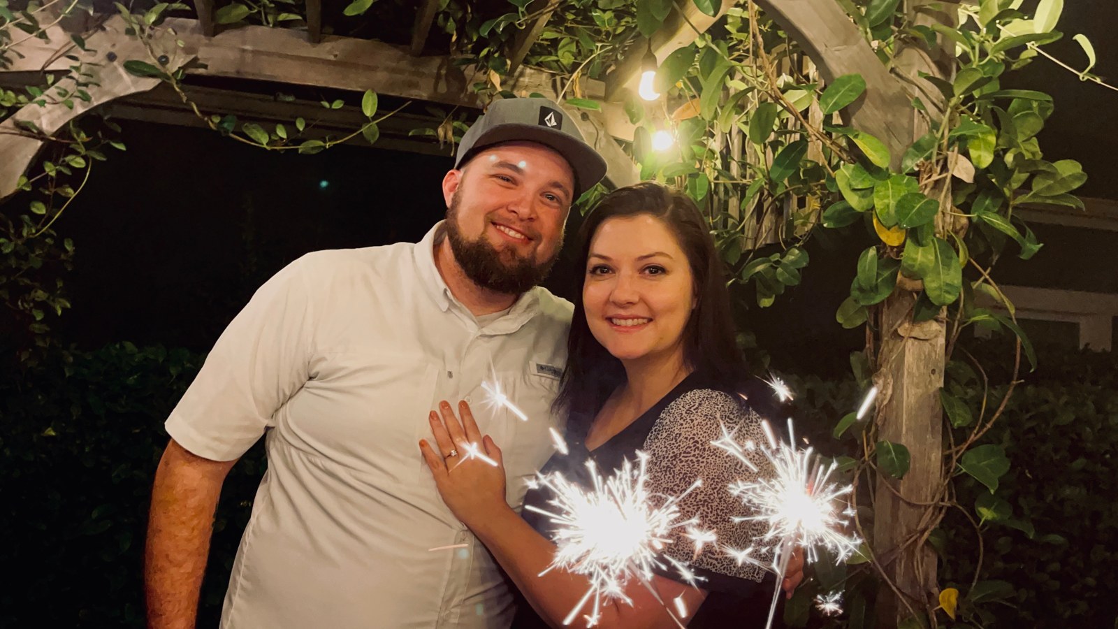 Ashley and Jacob celebrating their engagement with sparklers